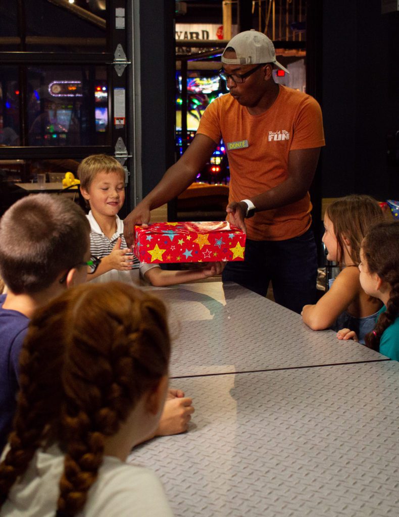 Child receiving a birthday gift at a kids birthday party