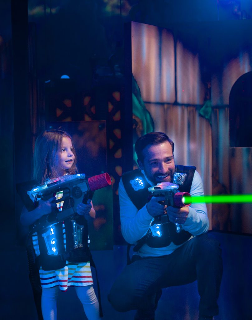 Father and daughter play laser tag