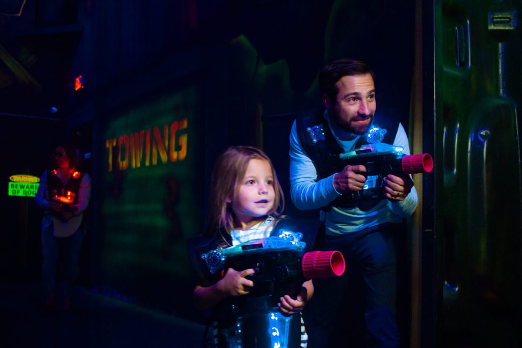 Father and daughter playing laser tag