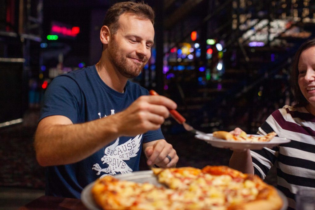 Man serves a slice of pizza