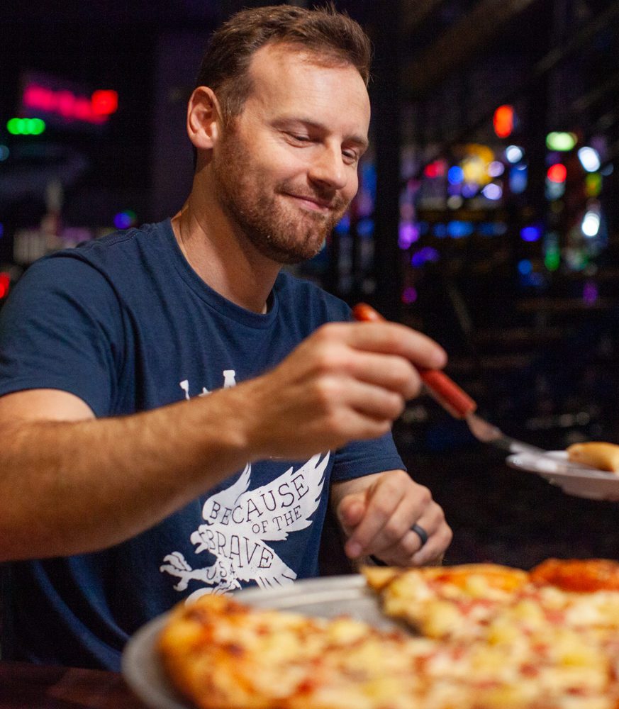 Man serves a slice of pizza