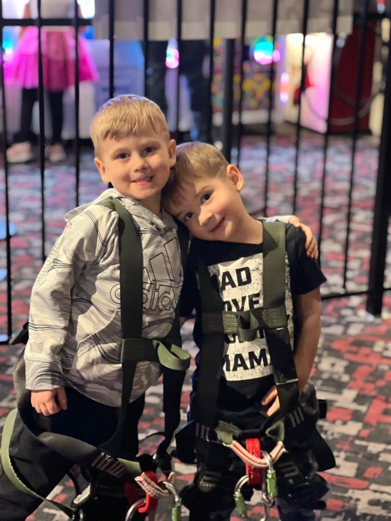 Two kids prepare to ride the zip line